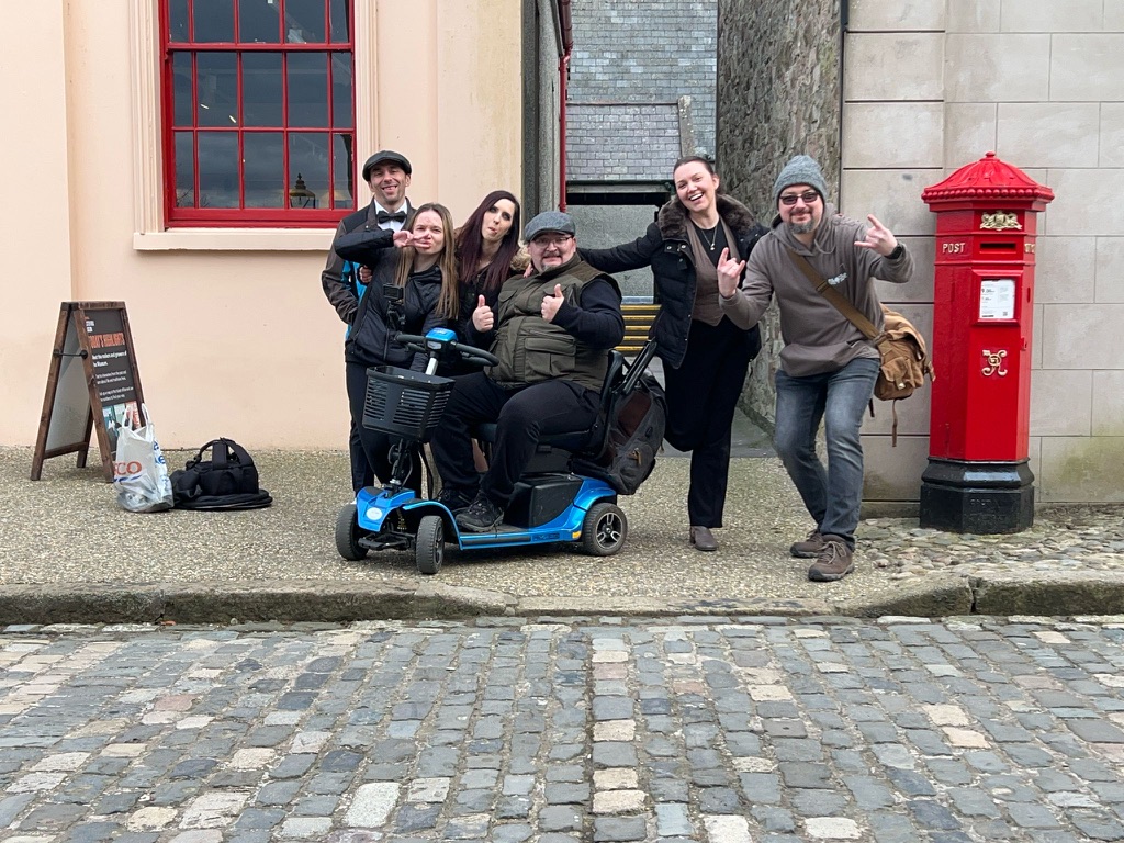 Lucas Malec on mobility scooter with friends in Belfast